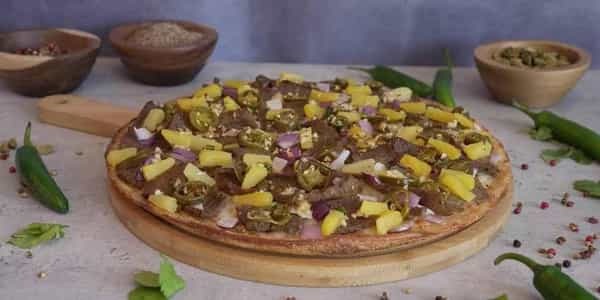 Spicy Lamb Kabob Pizza: Pizza topped with lamb, pineapple, and jalapeños on a wooden board.