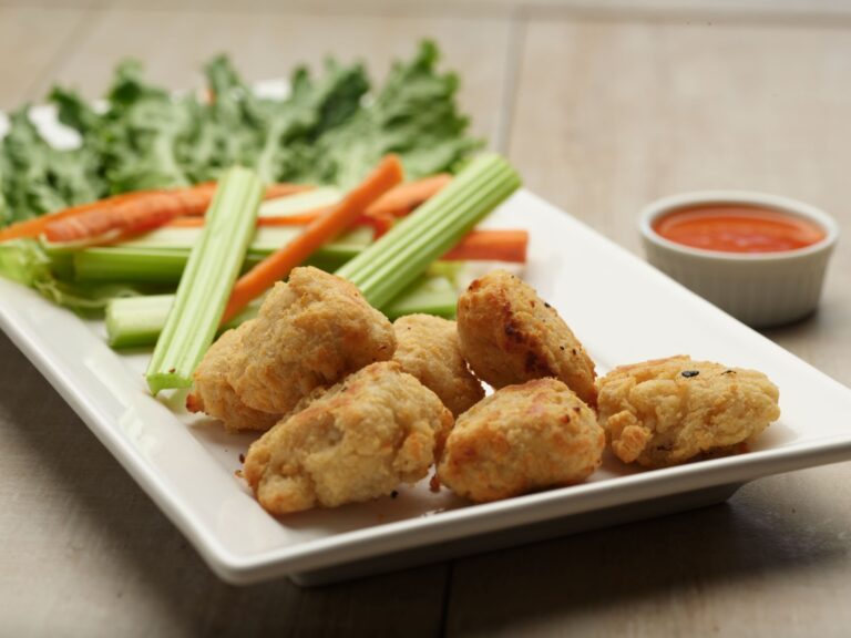 Plant-based soya wings served with celery, carrots, lettuce, and dipping sauce.