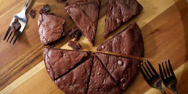 Pizza Brownie cut into slices on a wooden board with forks.