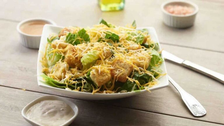Spring Caesar Salad with lettuce, croutons, shredded cheddar cheese, and creamy dressing.