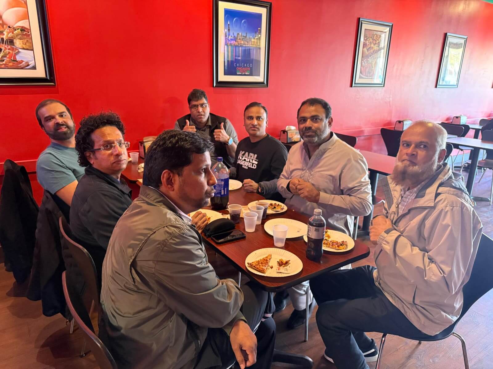 Group of men enjoying an unlimited pizza buffet, just $10, at a restaurant in Chicago.