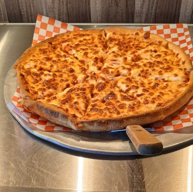 Freshly baked cheese pizza on a metal tray, ready for an unlimited pizza buffet.