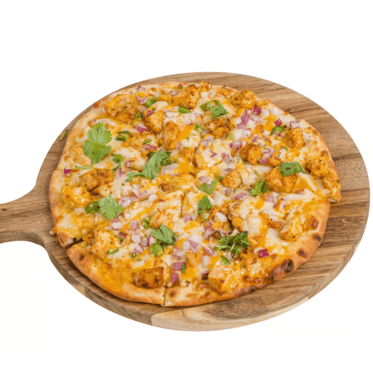 Butter chicken naan pizza with chicken, red onion, and cilantro on a wooden peel.