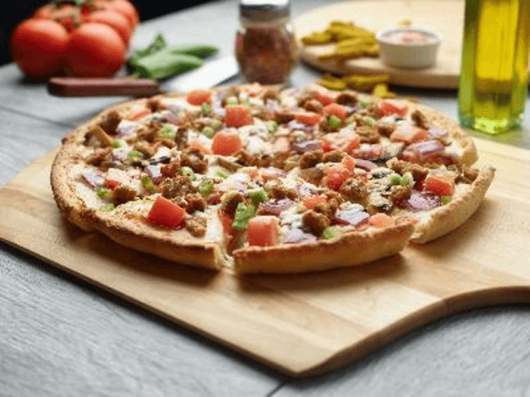 Delicious Italian garlic pizza topped with tomatoes, red onion, and crumbled meat.