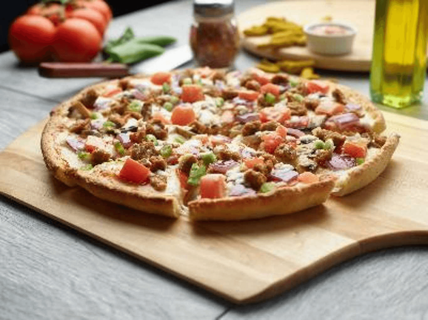 Delicious Italian garlic pizza topped with tomatoes, red onion, and crumbled meat.