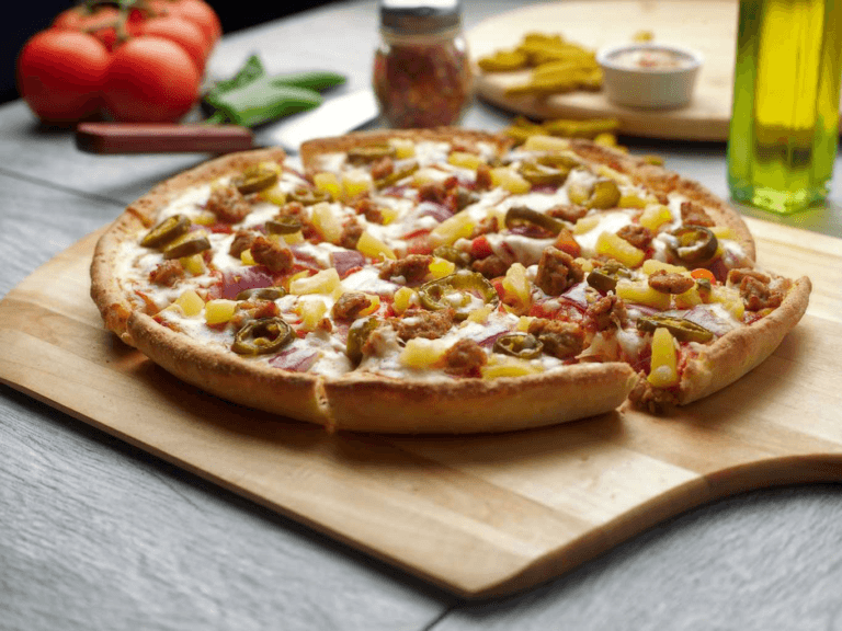 Hawaiian pizza with pineapple, jalapeños, sausage, and red onion