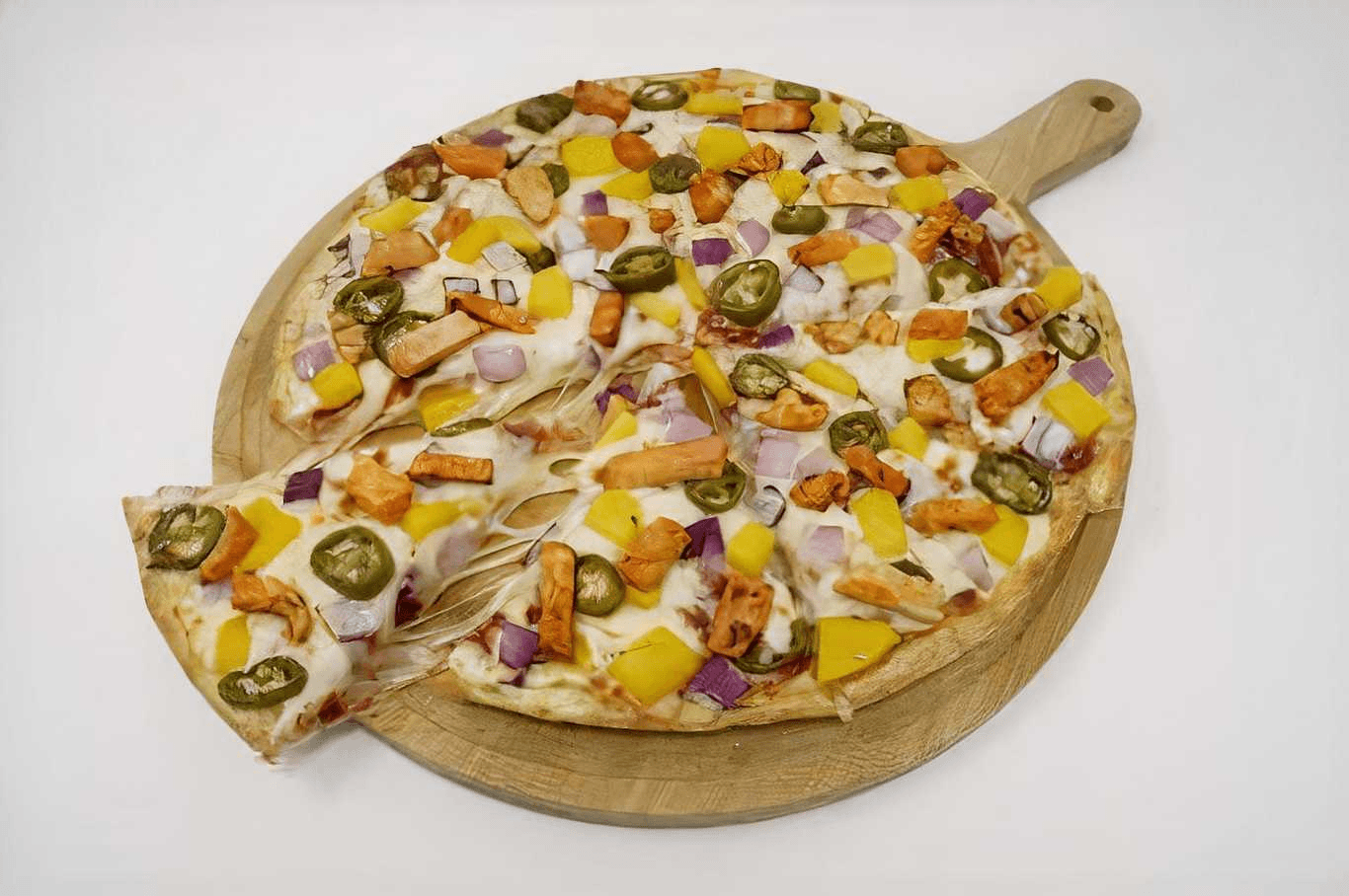 Delicious pizza with chicken, jalapeños, pineapple, and red onion on a wooden board.
